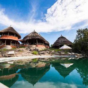 Several small huts on a rocky outcrop at mihingo lodge