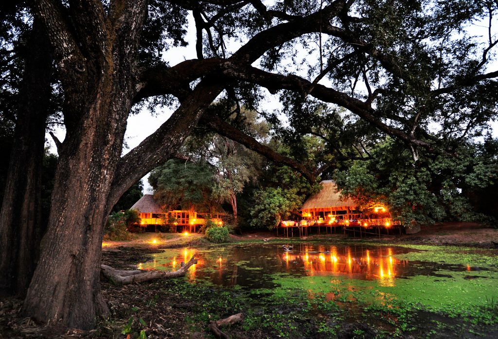 Bilimungwe bush camp early evening lights over the water hole