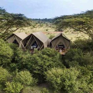 A safari tent in Kenya set amongst some trees'
