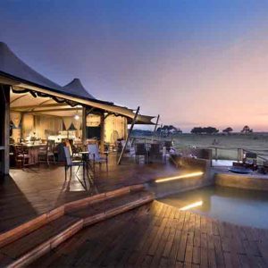 A deck with plunge pool and dining area at dusck