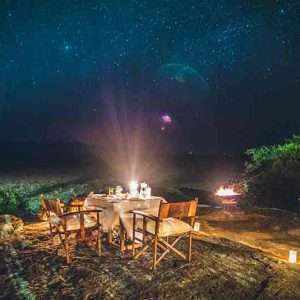 A dining table set out on a rock at night